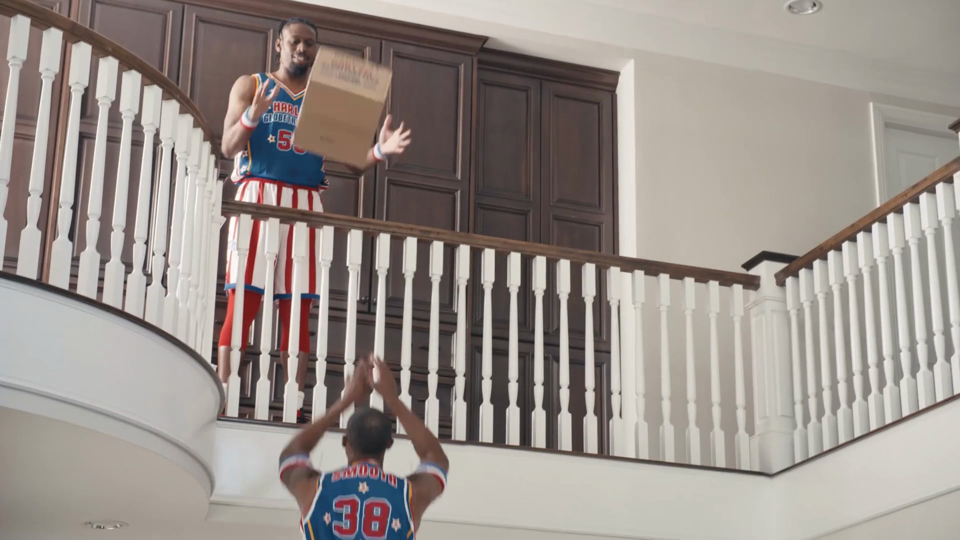 The Harlem Globetrotters pass a moving box over the upstairs railing